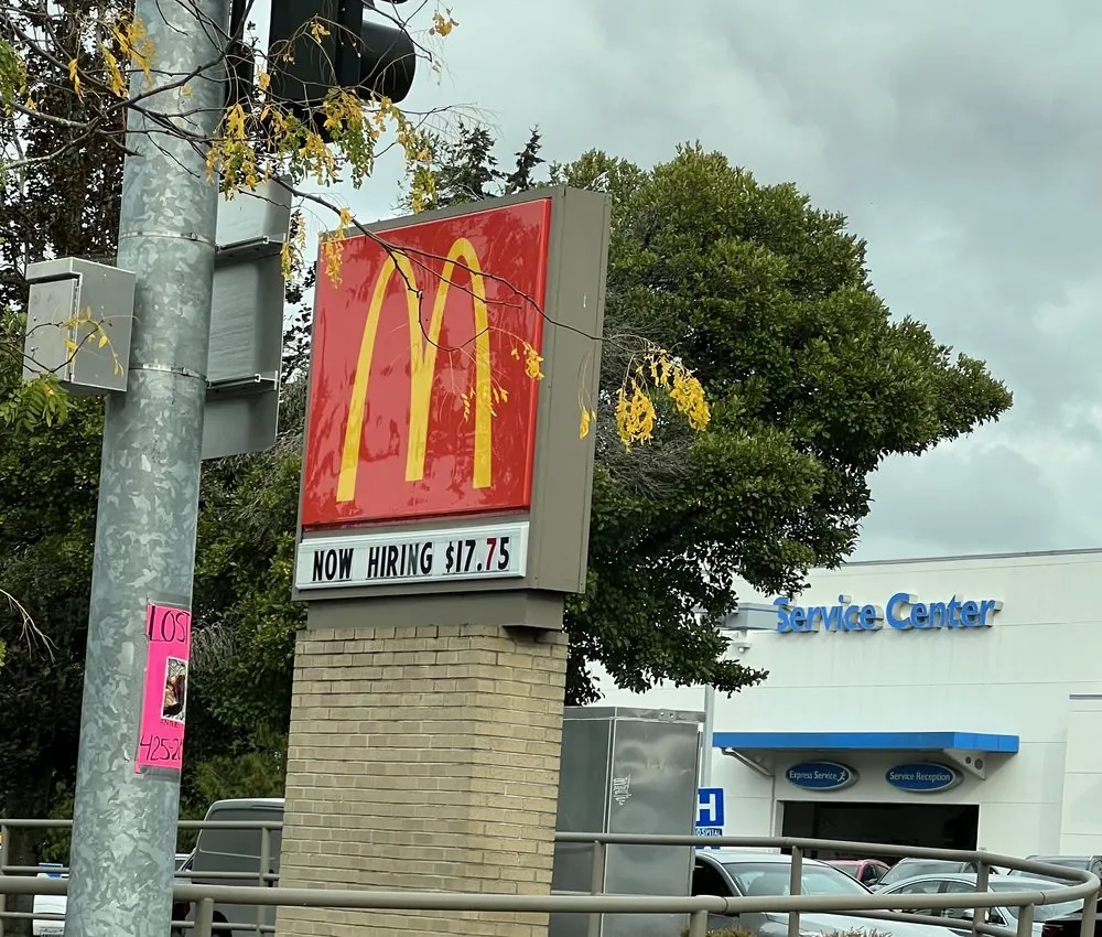 A McDonald’s sign by the road that reads NOW HIRING $17.75